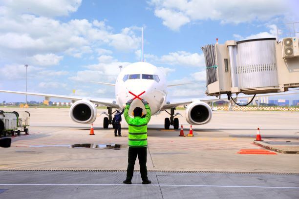Airline Worker Guiding Plane